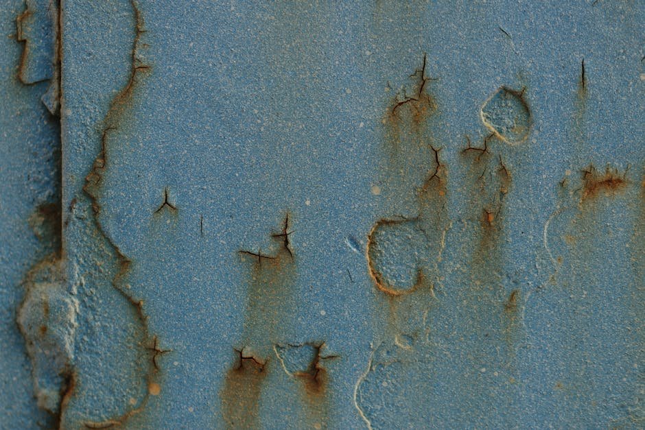 A detailed view of a rusty, cracked metal surface with textured patterns.