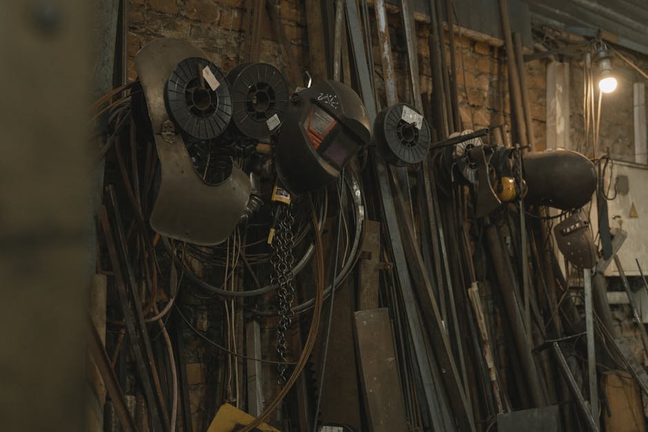 Dimly lit industrial workshop showcasing various welding tools and metal equipment.