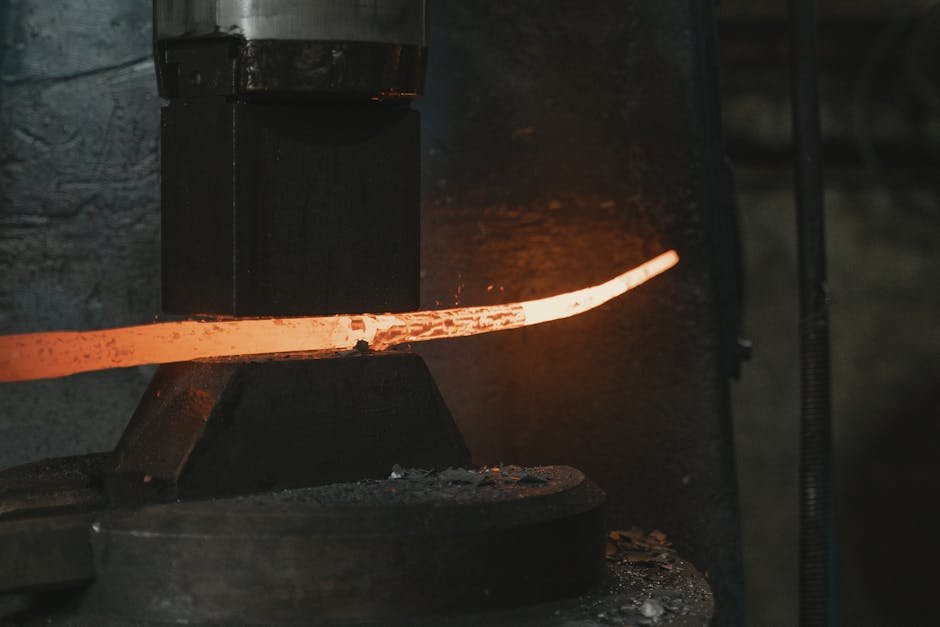 Close-up of hot iron being shaped in a forge, highlighting intense heat and craftsmanship.