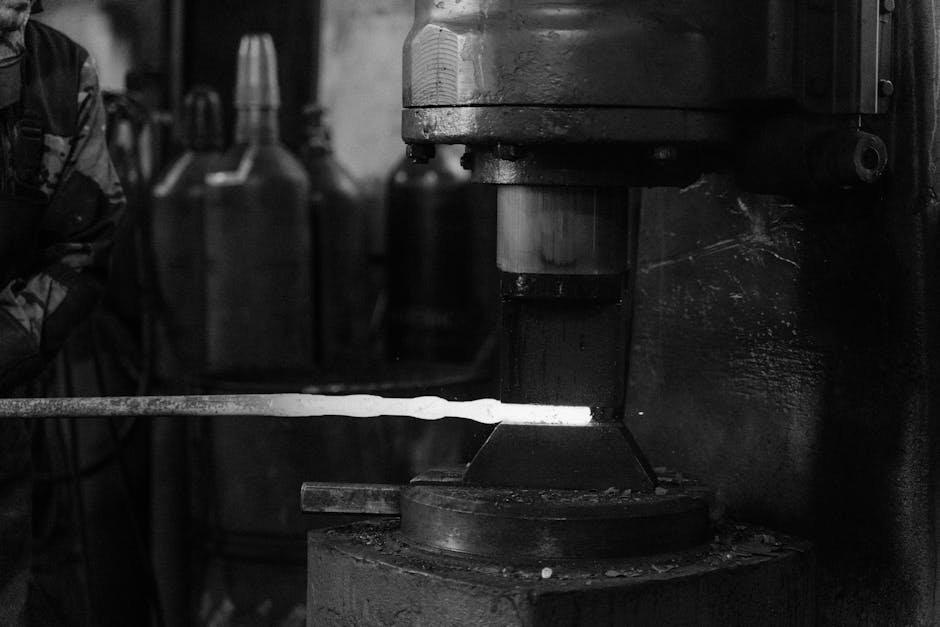 Monochrome image of a blacksmith's forge with metal being processed.