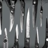 Flat lay of various scissors and cutting tools with stainless steel blades on a textured surface.