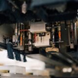 Detailed view of an industrial machine with multiple drills and brushes in a factory setting.