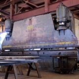 Massive metal press in a factory showcasing heavy machinery and industrial environment.